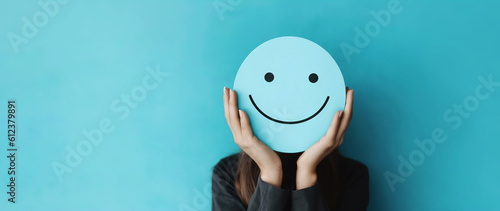 woman holding blue paper cut happy smile face, positive thinking, mental health assessment , world mental health day concept photo