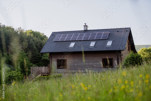 Family house with solar panels on the roof at meadow.