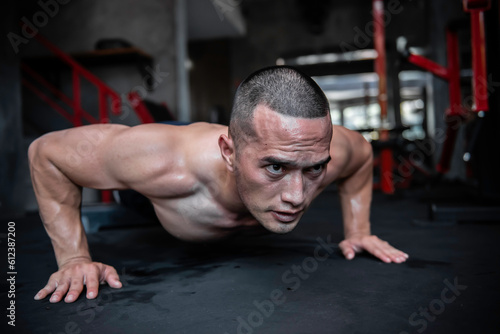 Fototapeta Naklejka Na Ścianę i Meble -  Portrait of asian man big muscle at the gym,Thailand people,Workout for good healthy,Body weight training,Fitness at the gym concept,spiderman plank