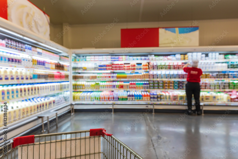 Defocused blur female of supermarket shelves with dairy products.