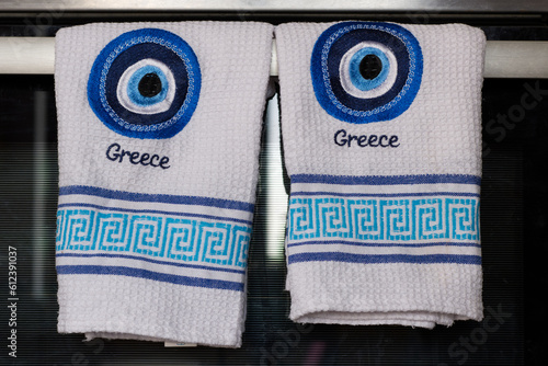 Greek evil eye embroidered on towels with the word Greece. Traditional greek symbol.