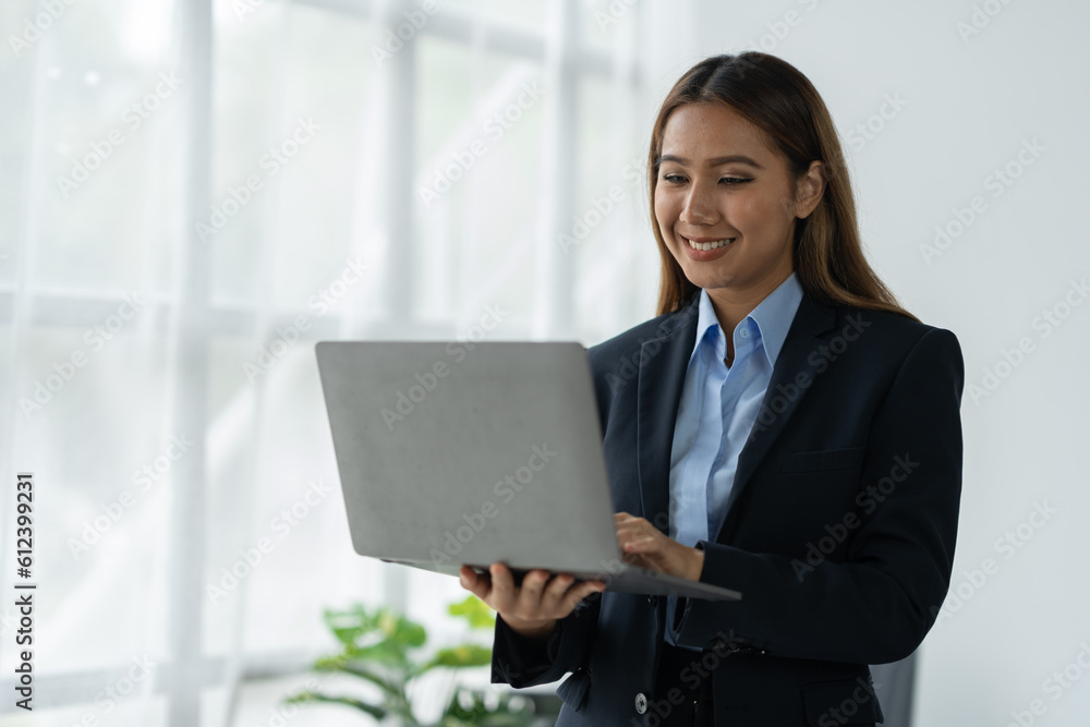 Businesswoman using a laptop computer with documents Calculator, notebook, on the table, planning, analyzing financial reports. business plan investment financial analysis concept Businesswoman using a laptop computer with documents Calculator, notebook, on the table, planning, analyzing financial reports. business plan investment financial analysis concept