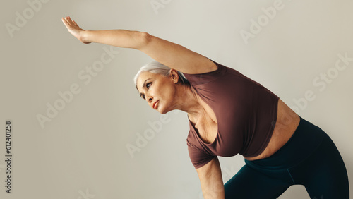 Mature woman doing the extended side angle pose during a yoga workout