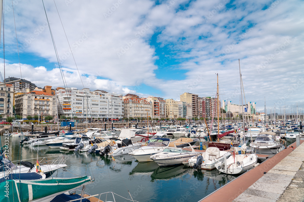 Santander, SPAIN - August 21 2022: Beautiful marina of Santander. Boats, yachts docked in the port. Travel destination in North of Spain. Panoramic view of marina and part of the city center. 