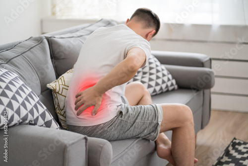 Fototapeta Back pain, kidney inflammation, man suffering from backache at home