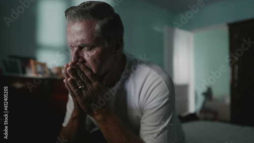 Desperate senior man covering face suffering from despair and lonliness. Older middle-aged person covering face in shame, struggling with anxiety and mental illness