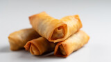 Close up shot of fried spring rolls against a white background
