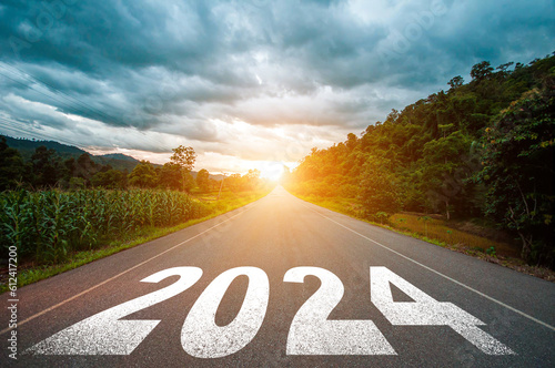 New year 2024 concept. Text 2024 written on the road in the middle of asphalt road with at sunset. Concept of planning, goal, challenge, new year resolution..