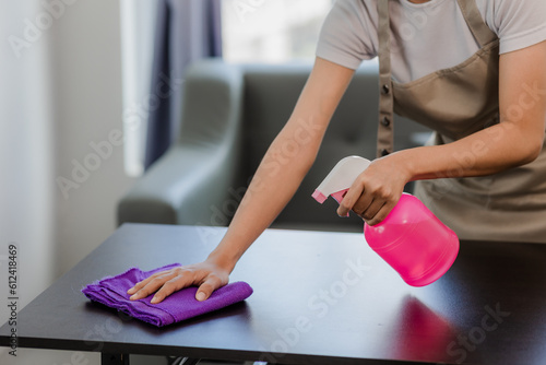 Cropped shot of beautiful young woman cleaning table at home