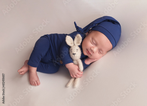 A newborn baby in a blue suit. The first photo session of a newborn.