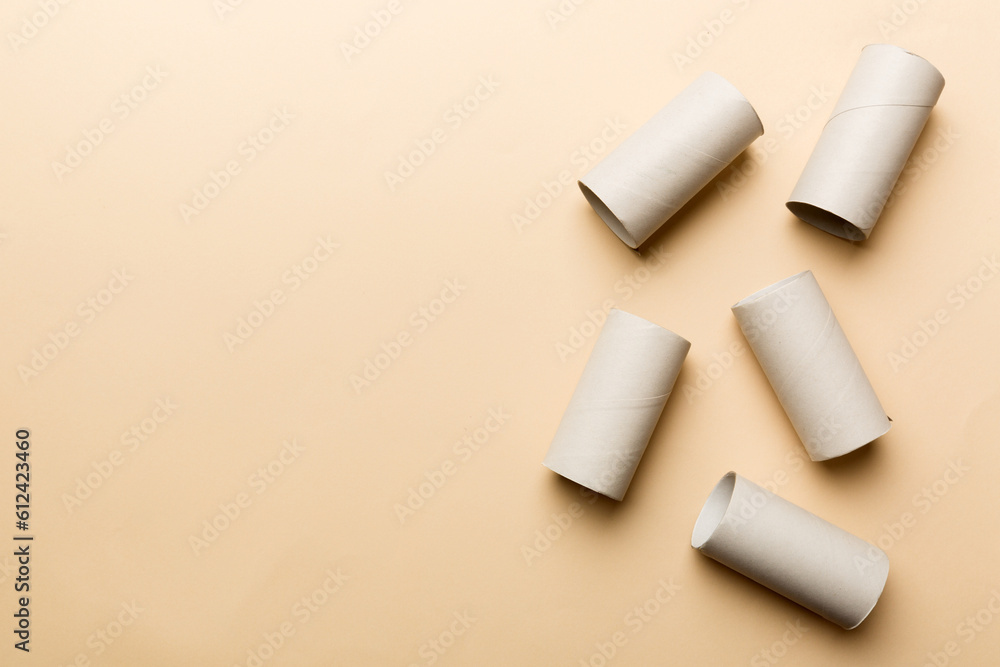 Fototapeta premium Flat lay composition with empty toilet paper rolls and space for text on color background. Recyclable paper tube with metal plug end made of kraft paper or cardboard