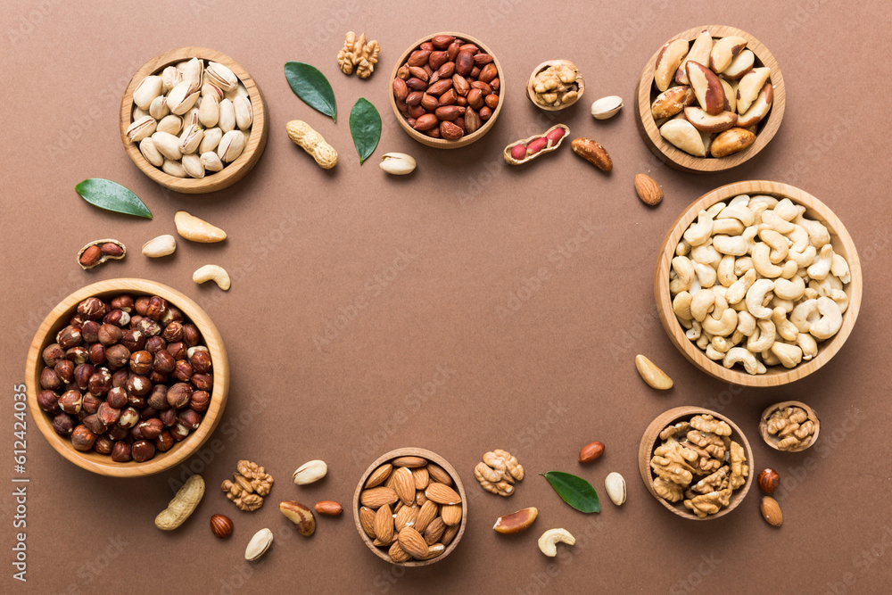 mixed nuts in wooden bowl. Mix of various nuts on colored background. pistachios, cashews, walnuts, hazelnuts, peanuts and brazil nuts mixed nuts in wooden bowl. Mix of various nuts on colored background. pistachios, cashews, walnuts, hazelnuts, peanuts and brazil nuts