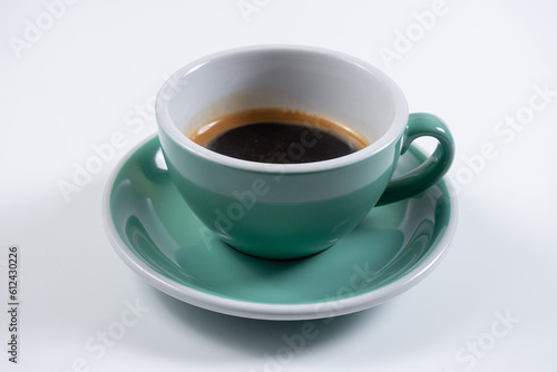 closeup of cup with espresso and saucer on white background