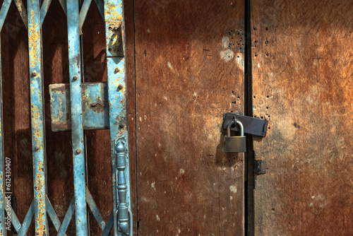 Quadro em tela Old gold steel lock and damaged and rusted steel door on wooden door