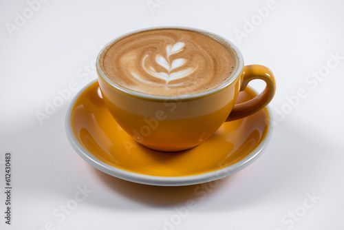 hot coffee latte with foam in yellow ceramic cup on white background