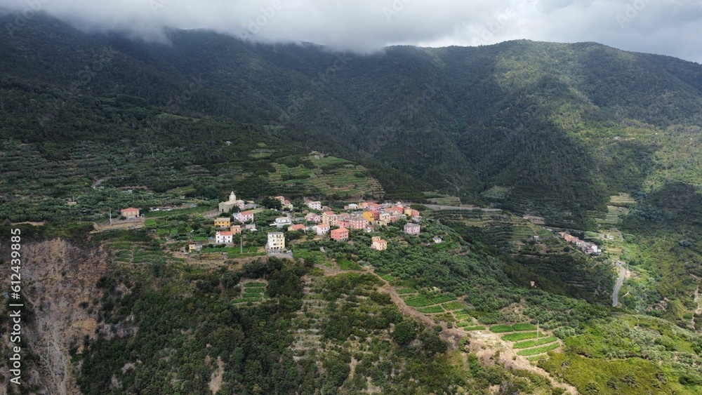 High-angle shot of a Cinque Terre village surrounded by beautiful lush mountains on an overcast day