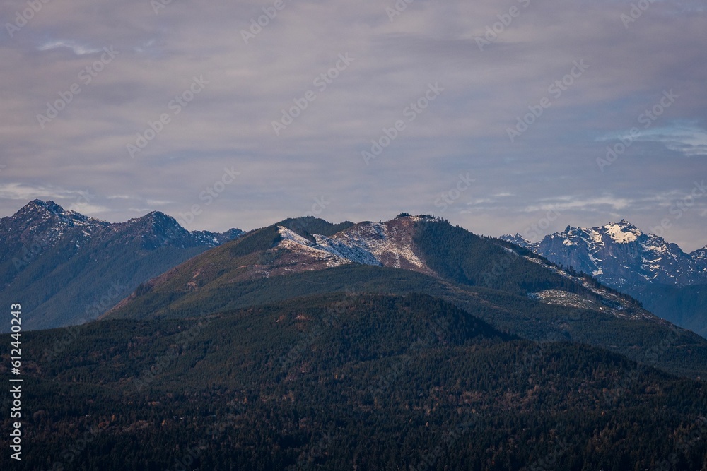 Fototapeta premium Beautiful shot of forested mountain landscapes under a cloudy sky