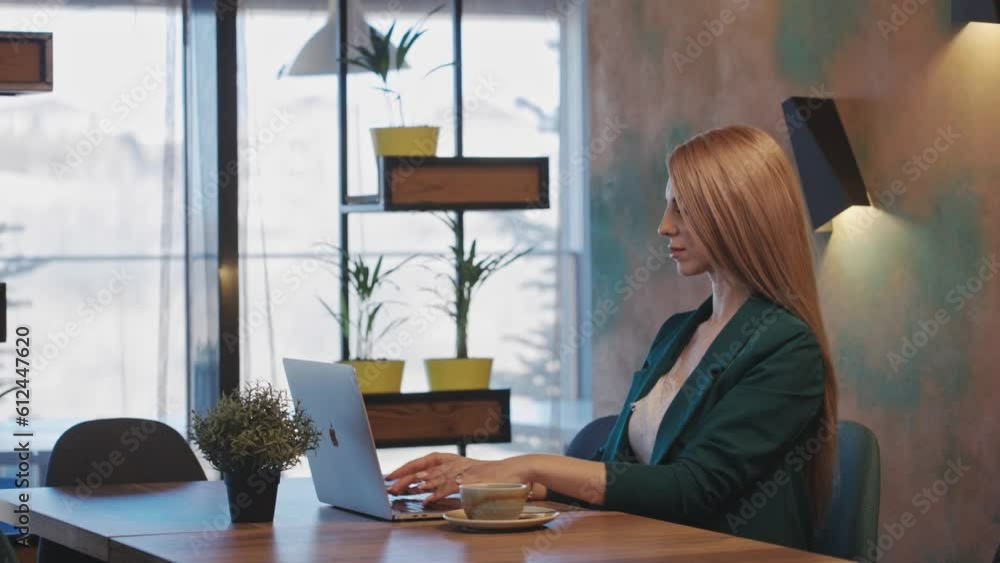 An elegant businesswoman wearing glasses works on her laptop in a hotel restaurant, sipping coffee. A Business woman browsing the Internet in a cafe. A beautiful woman relaxes in the office lobby. An elegant businesswoman wearing glasses works on her laptop in a hotel restaurant, sipping coffee. A Business woman browsing the Internet in a cafe. A beautiful woman relaxes in the office lobby.