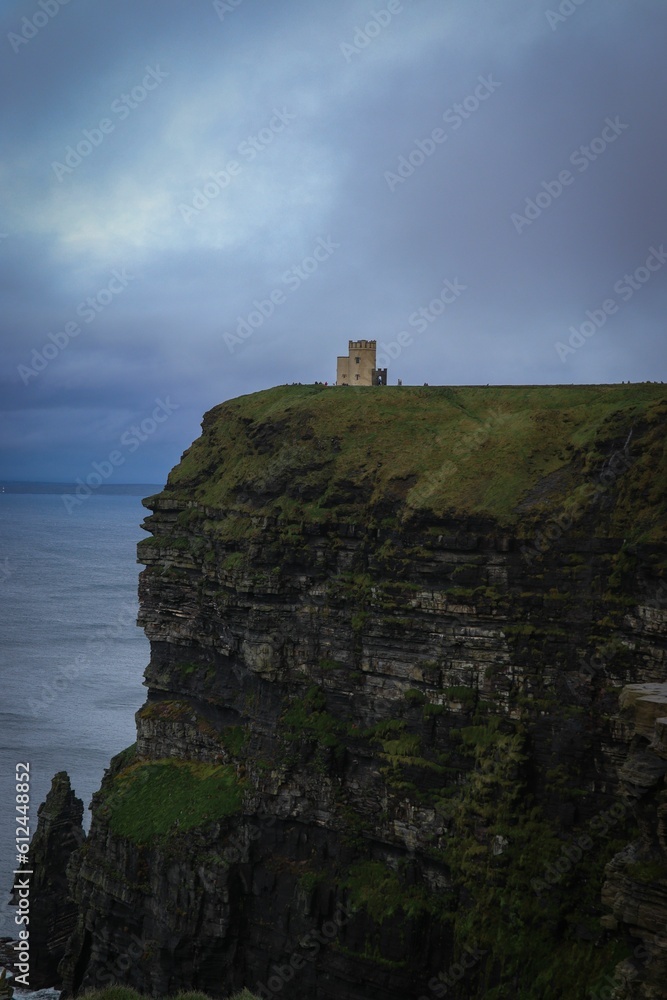 Vertical shot of the building on the cliff against a cloudy sky