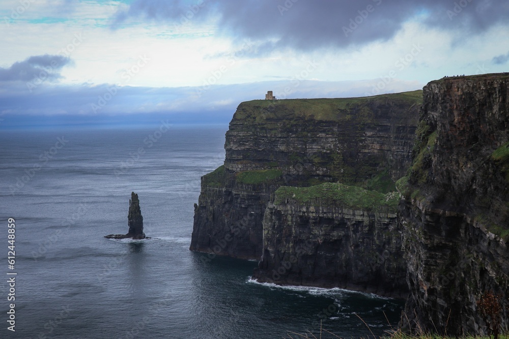 Cliffs of moher with a sea against a cloudy sky