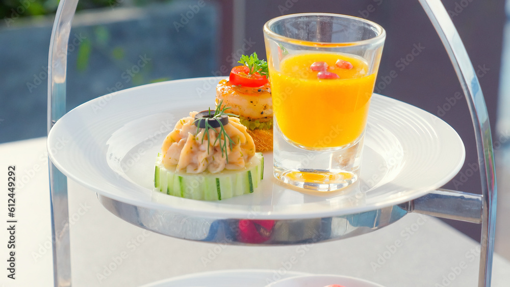Delicious appetizers on white plate in luxury restaurant. Snacks for cocktail hour in outdoor restaurant. Delicious appetizers on white plate in luxury restaurant. Snacks for cocktail hour in outdoor restaurant.