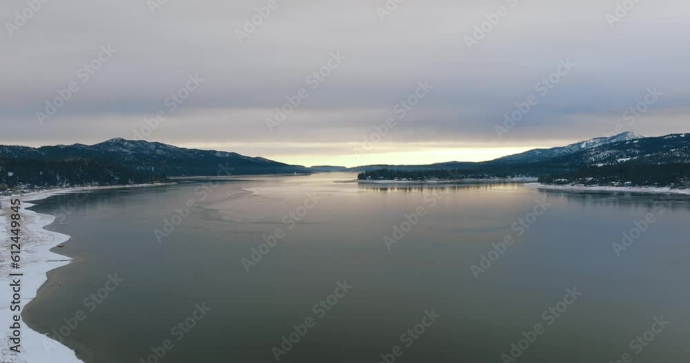 Drone view over forested hills on a waterfront during wintertime Drone view over forested hills on a waterfront during wintertime