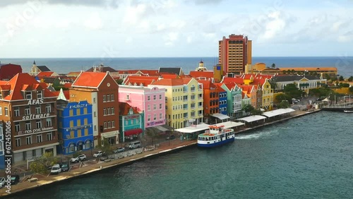 Willemstad, Curacao - 04.28.2021 View of colorful colonial buildings in the old historical city center of the town Willemstad and ferry waiting for tourists in canal 