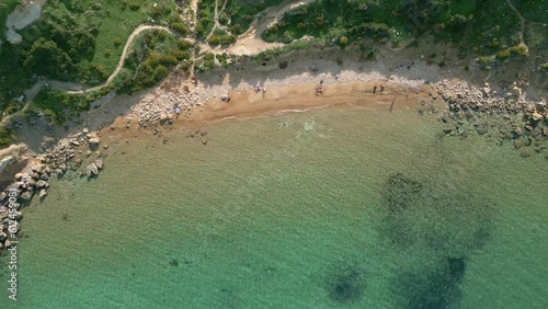 Aerial shot of the rocky mountains on the shore and a crystal clear sea, Malta, Imgiebah Bay photo