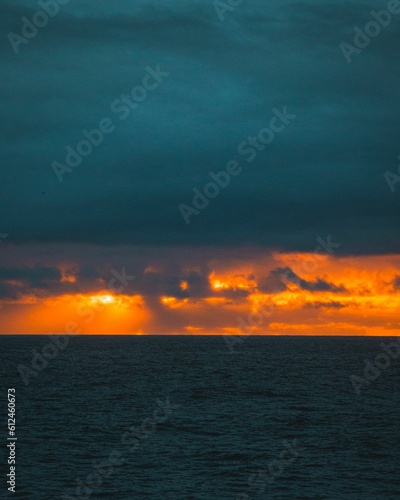 Vertical shot of the ocean during dramatic sunset