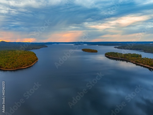 Aerial shot of a river and islands covered with trees during sunset