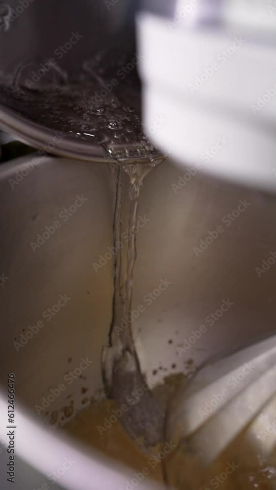 Pouring syrup into egg yolks. Pouring syrup into egg yolks.