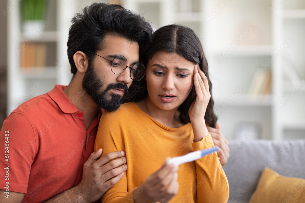 Unwanted Pregnancy. Worried young indian couple looking at positive test Unwanted Pregnancy. Worried young indian couple looking at positive test