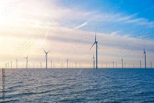 Offshore Windmill farm. windmills isolated at sea on a beautiful bright day Netherlands. green energy Flevoland global warming renewable enrgy with windmills