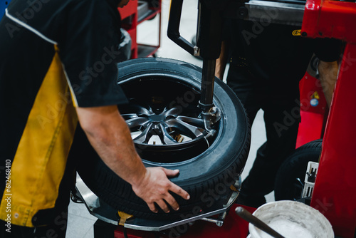 Mechanic changing tires on tire changer in Garage.