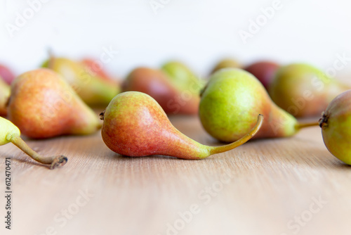 pear on a wooden table close-up in the foreground with a blurred background. © Juli Puli