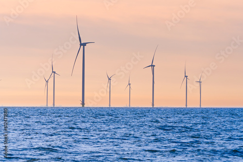 Offshore Windmill farm. windmills isolated at sea on a beautiful bright day Netherlands. green energy Flevoland global warming renewable enrgy with windmills