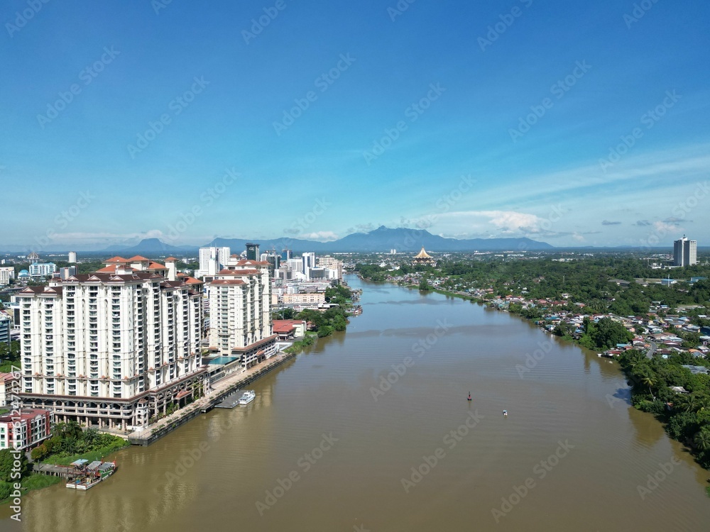 Naklejka premium Beautiful Sarawak River between Kuching city buildings, drone shot