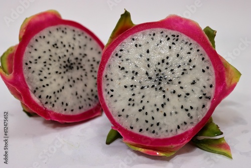 Closeup of a fresh dragonfruit cut in half on a white surface