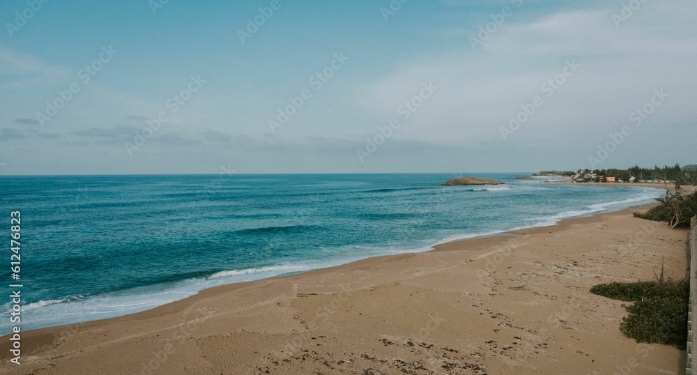 Scenic shot of an empty beach with calm waves