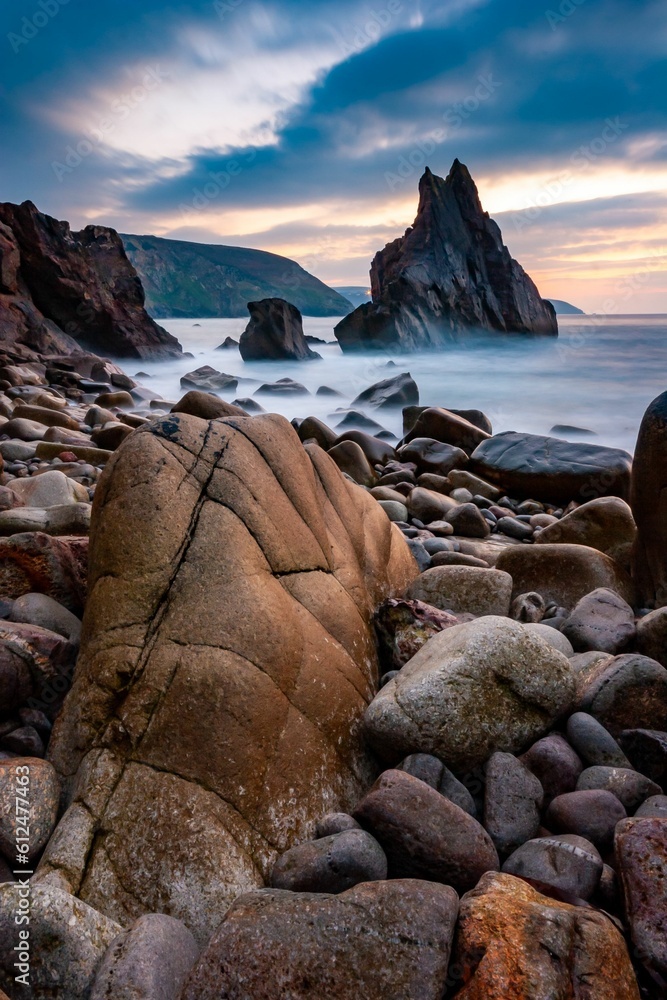 Vertical shot of a sea with rocks at sunset, long exposure Vertical shot of a sea with rocks at sunset, long exposure