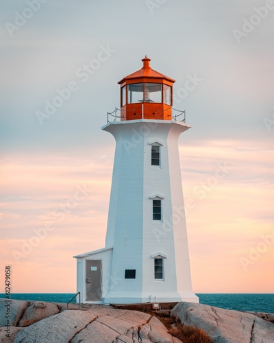 Vertical shot of a lighthouse on the shore at sunset