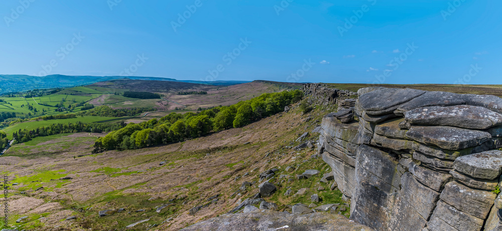 A panorama view looking back along the length of the Stanage Edge escarpment in the Peak District, UK in summertime