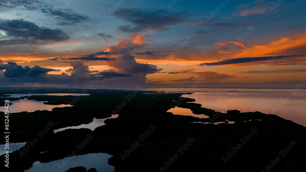 Gorgeous sunset with a blue and orange sky over the calm sea by the beach