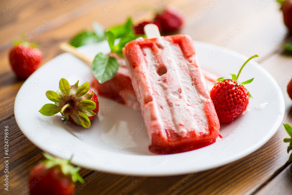homemade strawberry ice cream on a stick in a plate with strawberries homemade strawberry ice cream on a stick in a plate with strawberries