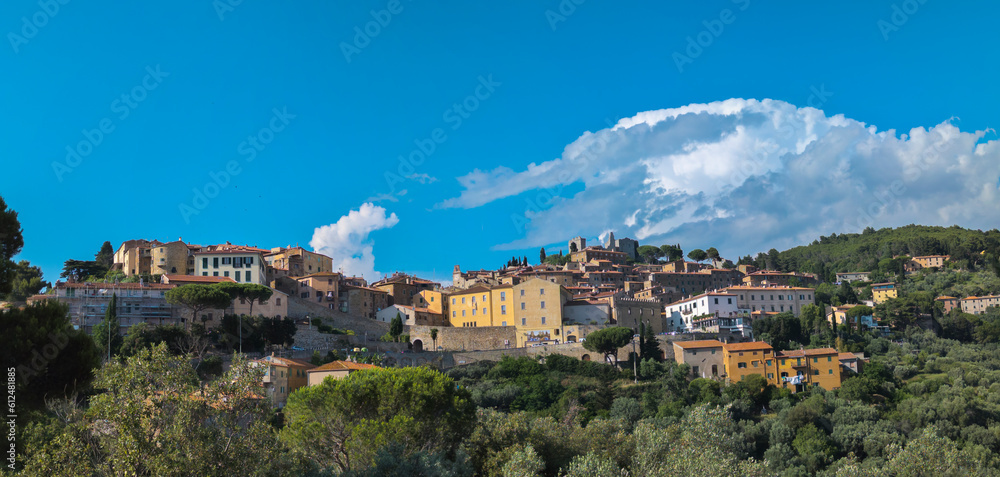 Panoramic view of the Tuscan town of Campiglia Marittima with blue sky and clouds