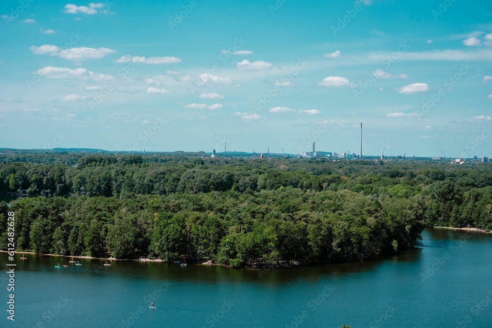 Scenic turquoise lake surrounding the coastal dense forests with leafy trees