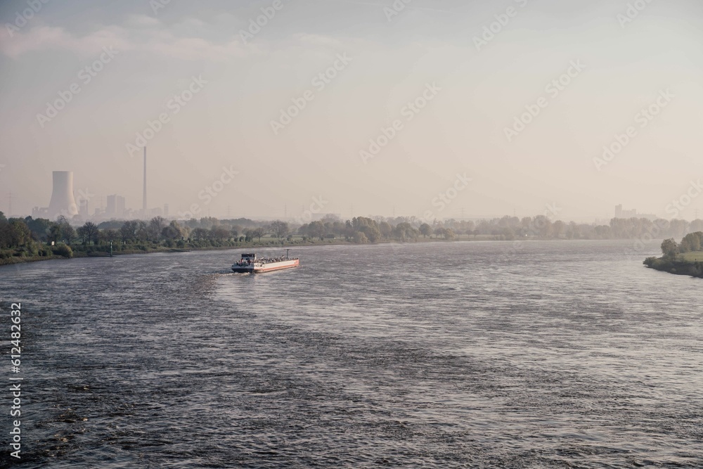 Ship on a voyage on the tranquil water of river Rhein in Duisburg, Germany