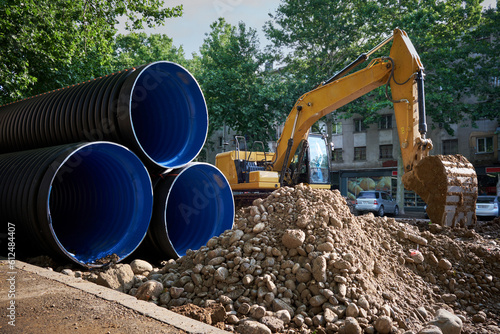 Large plastic corrugated pipes for water supply lie on the street in the city. photo