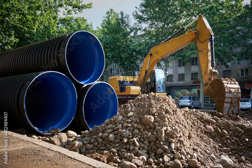 Fotografi Large plastic corrugated pipes for water supply lie on the street in the city