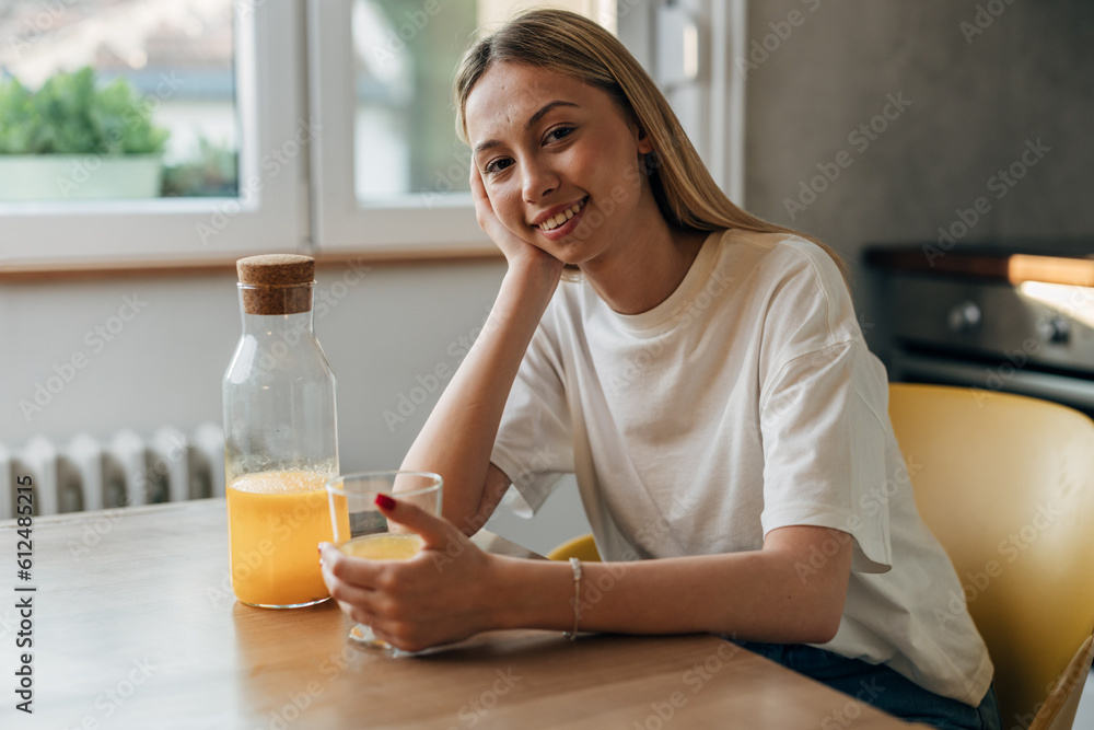 A beautiful woman is enjoying orange juice at home. A beautiful woman is enjoying orange juice at home.